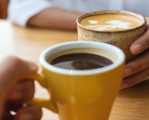 Two coffee cups about to touch